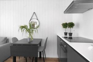 a kitchen with a table with a mirror and plants at Sommerbolig i byen in Kristiansand