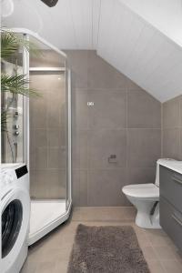 a bathroom with a shower and a washing machine at Sommerbolig i byen in Kristiansand