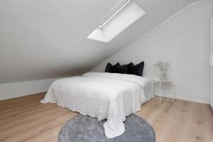 a white bedroom with a bed with a white blanket at Sommerbolig i byen in Kristiansand