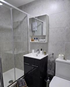 a bathroom with a shower and a sink and a toilet at Stylish 1 & 2 Bed Apartment - Desborough - Kettering - Sleeps up to 5 - Free Parking, - WIFI - Contractors, Professionals, Families and Relocators - By The Home Makers Hub in Kettering