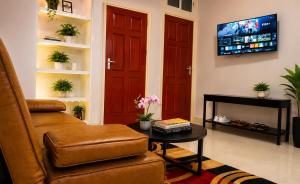 a living room with a chair and a tv at DOLFIJN STUDIOS 4 Spacious 2BR Apartment Fast WiFi AC North Paramaribo in Paramaribo