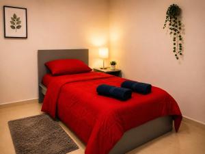a bedroom with a red bed with a red blanket at DOLFIJN STUDIOS 4 Spacious 2BR Apartment Fast WiFi AC North Paramaribo in Paramaribo