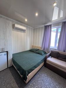 a bedroom with a bed and a couch in it at Гостевой дом Надежда in Zatoka