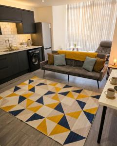 a living room with a couch and a kitchen at Stylish 1 & 2 Bed Apartment - Desborough - Kettering - Sleeps up to 5 - Free Parking, - WIFI - Contractors, Professionals, Families and Relocators - By The Home Makers Hub in Kettering