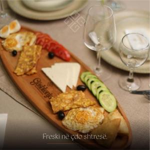 a plate of food with cheese and vegetables on a table at HotelRestaurant Gështenja in Suharekë