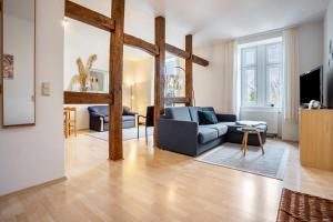 a living room with a blue couch and a table at Herrenhaus Carolinenhof in Groß Plasten
