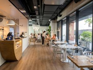 a restaurant with tables and people sitting at tables at Plac Wolności 6 airconditioning in Poznań