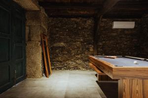 a room with a pool table and a stone wall at Provesende Douro Villas -Pateo Douro in Provesende