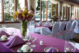 a table with a vase of flowers on a purple table cloth at Alamoosook Lakeside Inn Orland in Orland