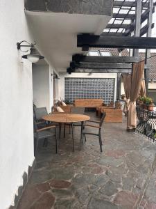 a patio with a table and chairs and a bench at Vila TeoNa in Topliţa