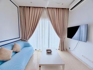 a living room with a blue couch and a table at Lucentia residence luxury suites in Kuala Lumpur