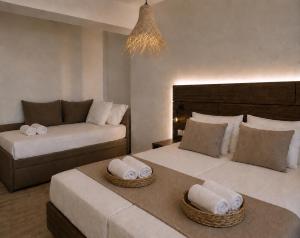 a hotel room with two beds and a couch at Este Luxury Apartments in Kriopigi