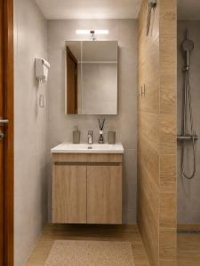 a bathroom with a sink and a mirror and a shower at Este Luxury Apartments in Kriopigi +36 photos