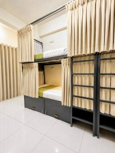 a bedroom with bunk beds with curtains at VELORA DORMs in Ujjain +12 photos