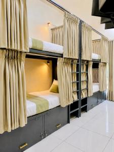 two bunk beds in a room with curtains at VELORA DORMs in Ujjain