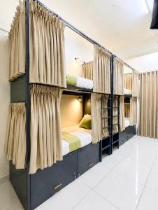 a room with four bunk beds with curtains at VELORA DORMs in Ujjain