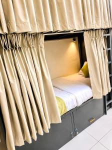 a bedroom with a bunk bed with curtains at VELORA DORMs in Ujjain