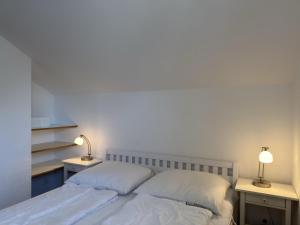 a bedroom with a bed with two lamps on two tables at Ferienwohnung in Burhave in Burhave