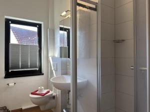 a bathroom with a toilet and a sink and a shower at Ferienwohnung in Burhave in Burhave +21 photos