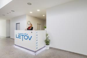 a woman standing behind a reception desk in an office at Hotel & Hostel Letov in Prague