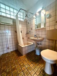 a bathroom with a tub and a toilet and a sink at Cozy cottage in Lichtenau
