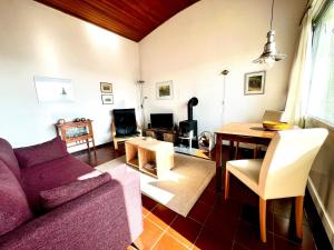 a living room with a purple couch and a table at Cozy cottage in Lichtenau