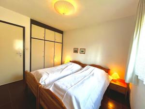 a bedroom with a large bed with white sheets at Cozy cottage in Lichtenau