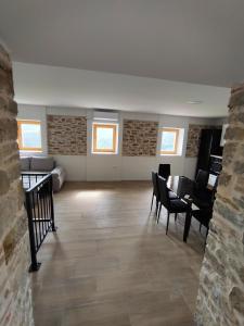 a living room with a stone wall and a table and chairs at Roman Paradise Villa with Pool in Koper +14 photos