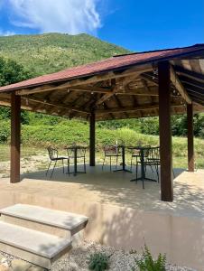 a wooden pavilion with tables and chairs in front of a hill at B&B Clav's Home - bebclavshome in Pozzilli +24 photos
