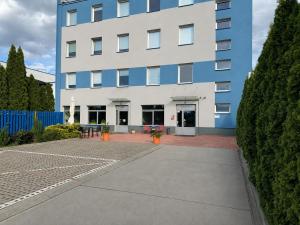 a blue and white building with a courtyard at Pokoje & Bistro Mielec in Mielec