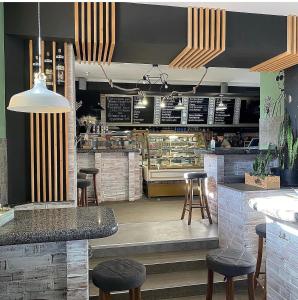 a restaurant with a bar with stools and a counter at ЭКО готель ,,Челентано ,, in Slavuta
