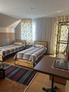 a hotel room with two beds and a table at ЭКО готель ,,Челентано ,, in Slavuta