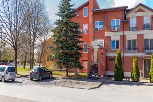 a car parked in front of a building with a christmas tree at Parko Studija in Birštonas