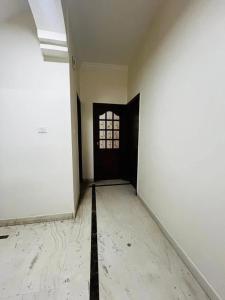 an empty hallway with a door and a window at U K I Guest House in Bangalore +2 photos