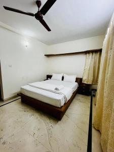 a bedroom with a bed with a ceiling fan at U K I Guest House in Bangalore