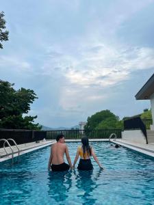 a man and woman standing in a swimming pool at Cloud&Rey Rentals in Roxas City