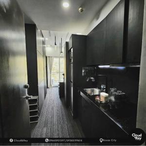 a black kitchen with a sink and a counter at Cloud&Rey Rentals in Roxas City