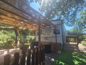a wooden pergola with a table and chairs in a yard at Casa à leccia in Rapale +6 photos
