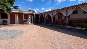 a house with a gravel driveway in front of it at Pousada Moaçara in Estivado