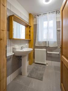 a bathroom with a sink and a window at Mansarda al Lago Casa Lavaredo in Auronzo di Cadore