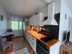 a kitchen with white cabinets and a wooden counter top at Juurikkalahti Adventure Center in Kajaani