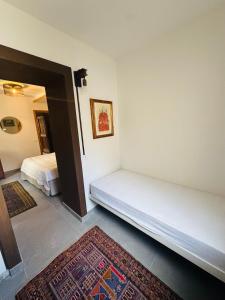 a room with two beds and a rug in it at Mansarda al Lago Casa Lavaredo in Auronzo di Cadore