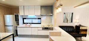 a kitchen with white cabinets and a black chair at guesthouse嵐 in Osaka