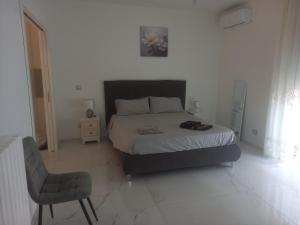 a bedroom with a bed and a chair in it at BEB LA Perla in Sammichele di Bari