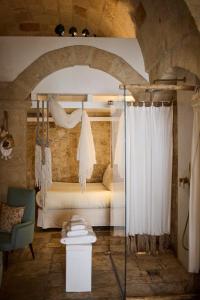 a bedroom with a bed in a room with a curtain at Dei Serafini in Polignano a Mare +181 photos