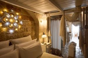 a bedroom with a bed and a wall with a mirror at Dei Serafini in Polignano a Mare