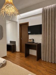 a living room with a table and a television at Este Luxury Apartments in Kriopigi