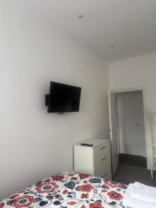 a bedroom with a bed and a flat screen tv on the wall at Nest in Northumberland 2 in Blythe