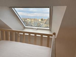 a bed in a room with a window at Sur les toits de Beaugency in Beaugency