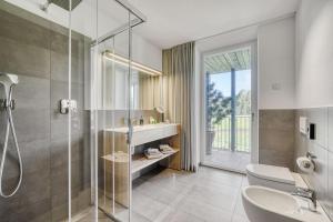 un bagno con doccia, WC e lavandino di Hotel Lichtenstern a Soprabolzano Altre 67 foto
